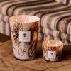 Baobab Collection Anangu candles on wooden table, showcasing hand-blown glass with unique brown motifs, lit for ambiance.