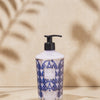 Baobab Collection Manhattan hand and body lotion in decorative bottle on a plate, featuring cream and navy design.