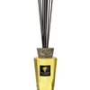Baobab Collection TOTEM LES EXCLUSIVES AURUM diffuser with gold tint and ceramic cap, featuring black fragrance sticks.