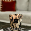Baobab Collection candle in hand-blown glass, beautifully styled on a table with decor background.
